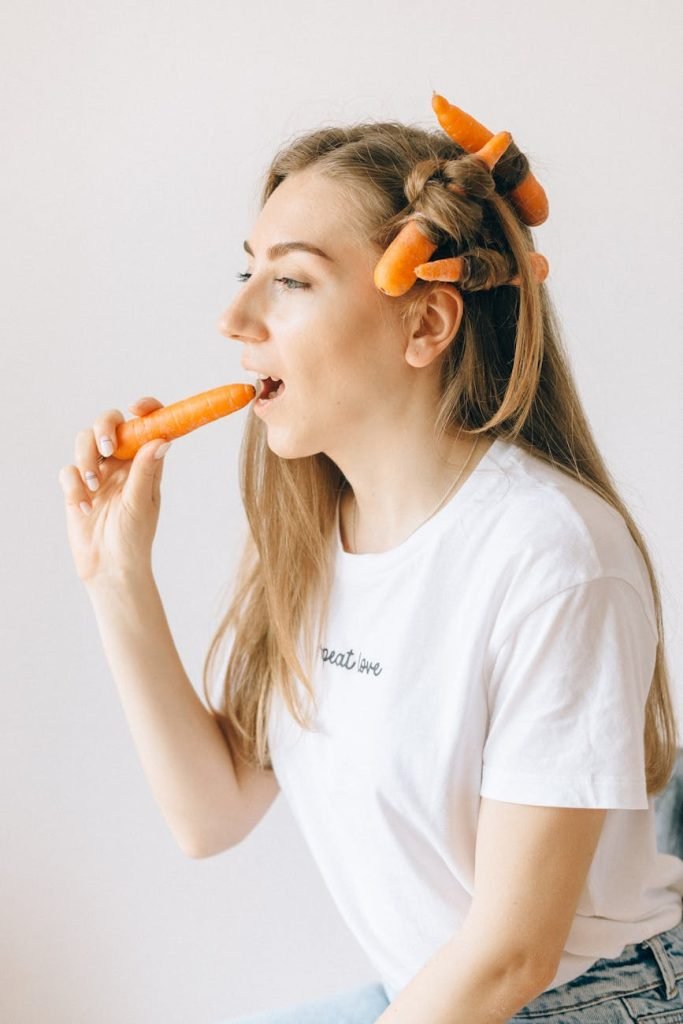 How Nutrition Affects Your Scalp and Hair Health: Trichologist’s Guide woman in white top with carrots on hair